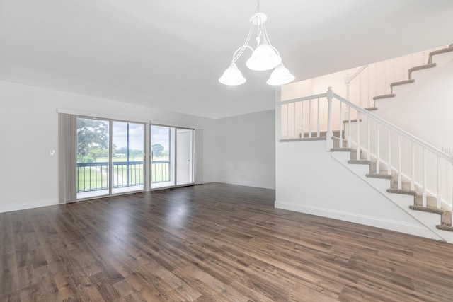 unfurnished living room with dark hardwood / wood-style floors and a notable chandelier