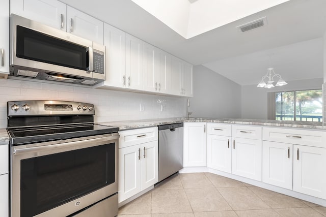 kitchen featuring decorative backsplash, appliances with stainless steel finishes, kitchen peninsula, white cabinets, and a chandelier