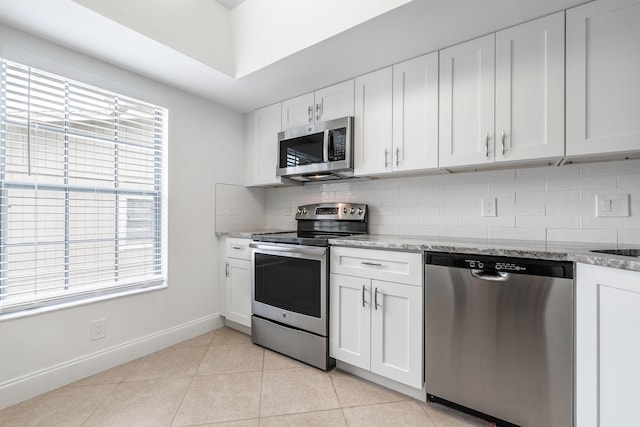 18520 SE Wood Haven Ln Unit I, Jupiter, FL 33469 - kitchen with stainless steel appliances, backsplash, baseboards, light stone counters, and white cabinets
