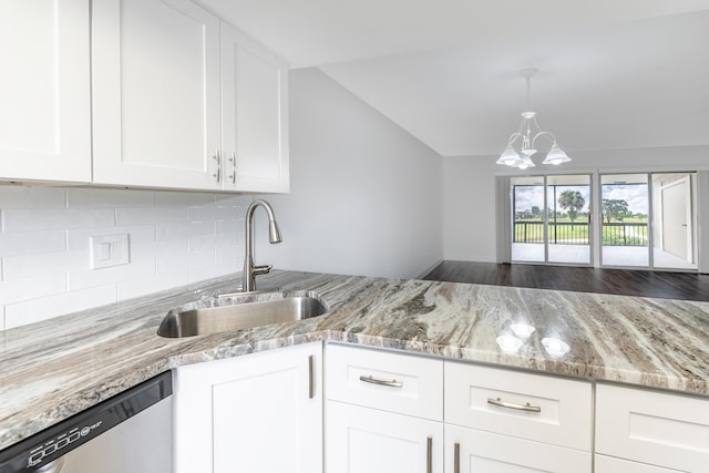 kitchen with sink, stainless steel dishwasher, light stone counters, white cabinetry, and a chandelier