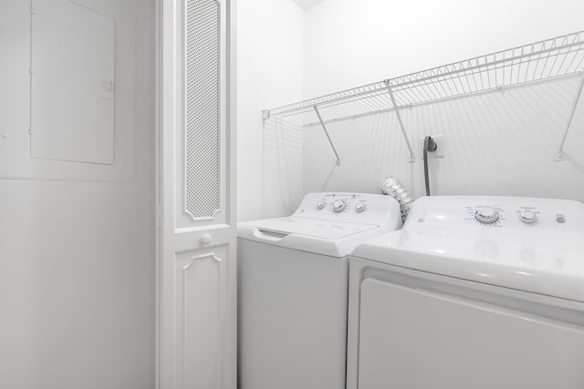 laundry area with electric panel and washing machine and clothes dryer