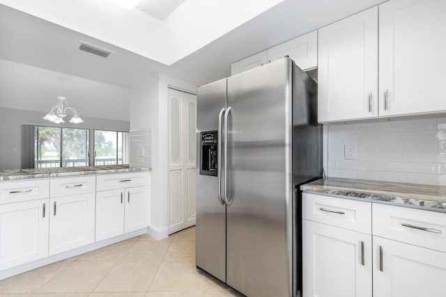 18520 SE Wood Haven Ln Unit I, Jupiter, FL 33469 - kitchen featuring stainless steel refrigerator with ice dispenser, a chandelier, decorative backsplash, white cabinets, and light stone counters