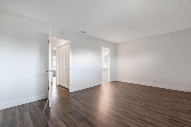 spare room with dark wood-type flooring