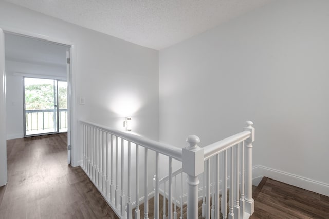 18520 SE Wood Haven Ln Unit I, Jupiter, FL 33469 - corridor featuring an upstairs landing, wood finished floors, baseboards, and a textured ceiling