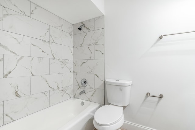 bathroom featuring tiled shower / bath combo and toilet