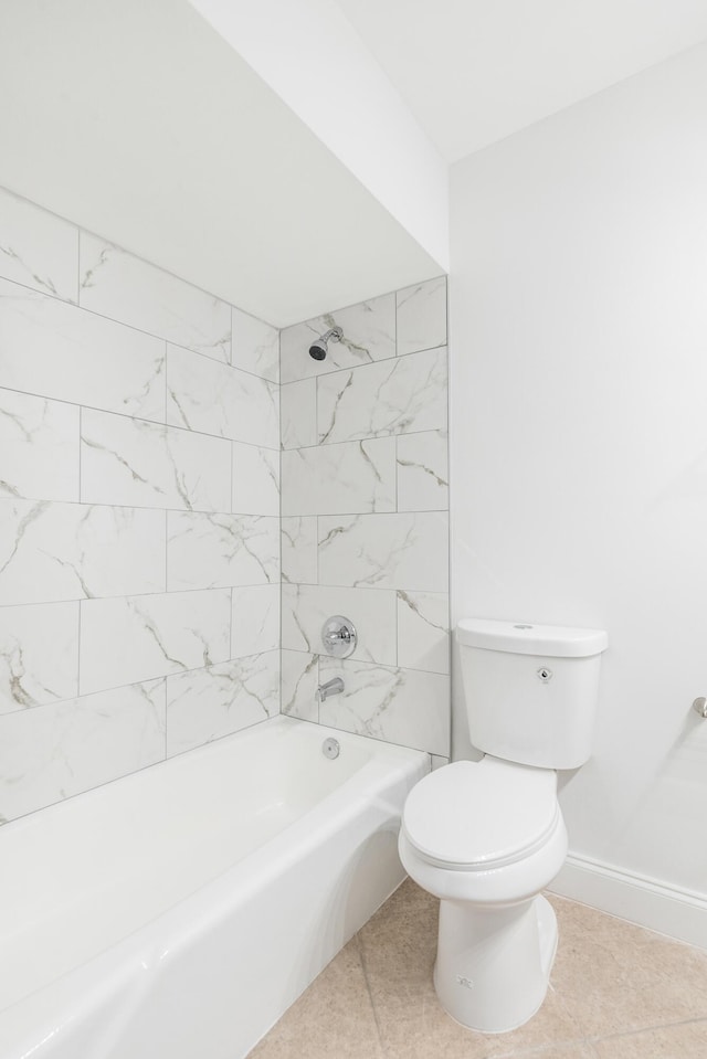 bathroom with tile patterned flooring, toilet, and tiled shower / bath