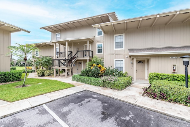 18520 SE Wood Haven Ln Unit I, Jupiter, FL 33469 - view of building exterior featuring stairs and uncovered parking