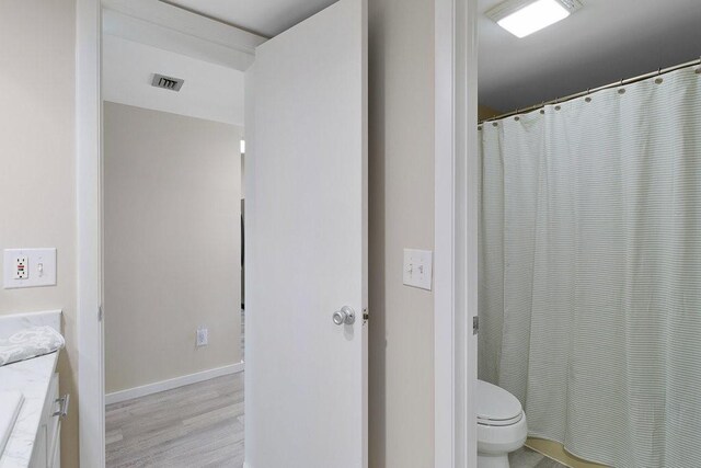 bathroom featuring hardwood / wood-style flooring, vanity, and toilet