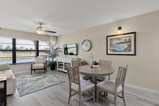 living room featuring a textured ceiling, light hardwood / wood-style floors, and ceiling fan