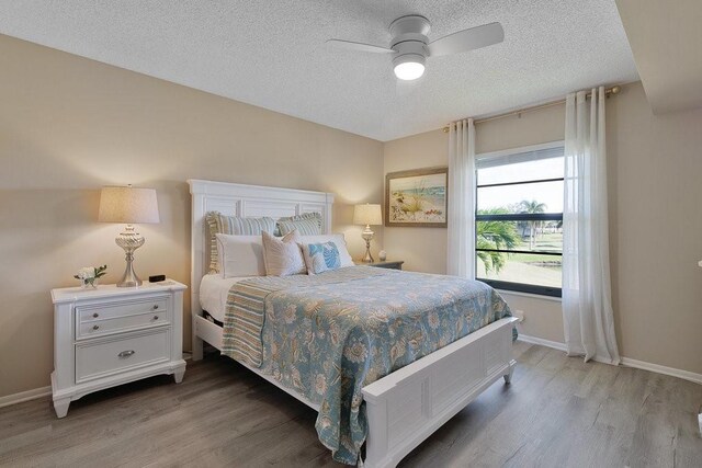 bedroom featuring wood-type flooring, a textured ceiling, and ceiling fan