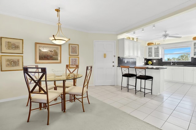 dining space featuring light tile patterned flooring, sink, ceiling fan, and crown molding