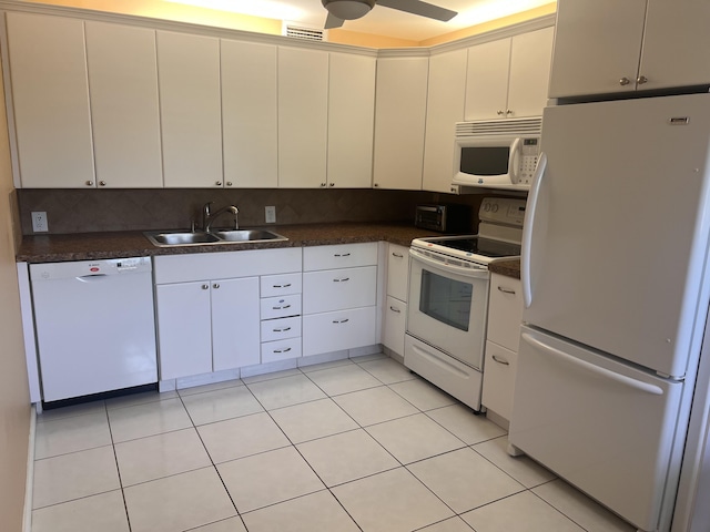 kitchen with white appliances, white cabinets, sink, light tile patterned floors, and tasteful backsplash