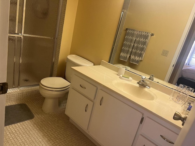 bathroom featuring toilet, vanity, tile patterned floors, and a shower with door