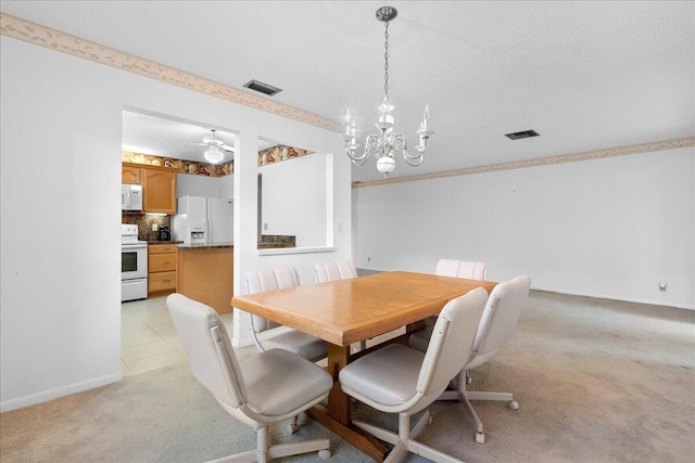 dining space with light carpet, a textured ceiling, visible vents, and a notable chandelier