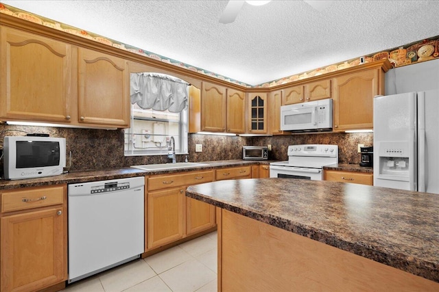 kitchen featuring white appliances, decorative backsplash, dark countertops, glass insert cabinets, and a sink