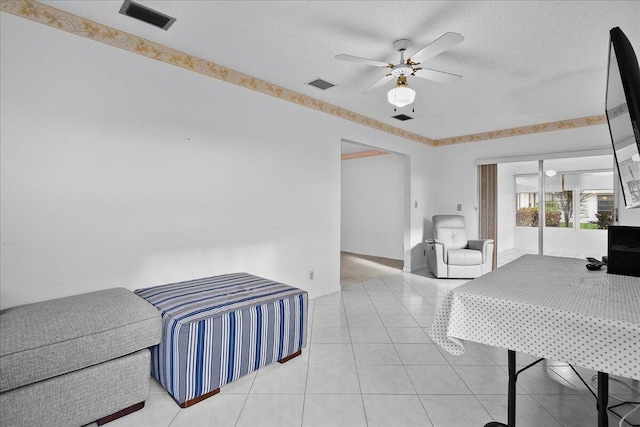 bedroom with visible vents, a textured ceiling, and light tile patterned floors