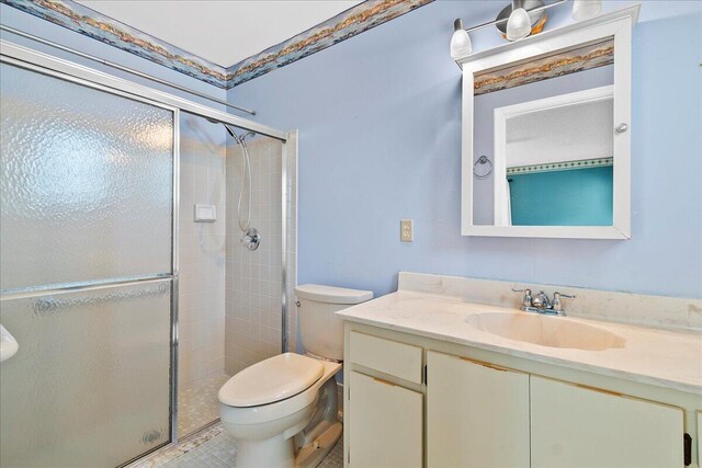 bathroom featuring a stall shower, vanity, and toilet