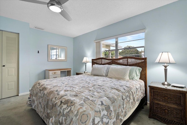 bedroom with a textured ceiling, visible vents, baseboards, a ceiling fan, and dark carpet