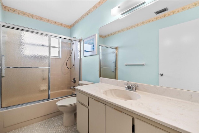 bathroom featuring toilet, shower / bath combination with glass door, vanity, visible vents, and tile patterned floors