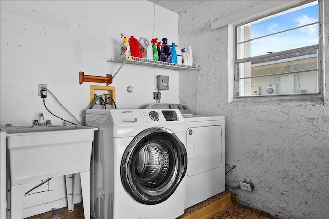 laundry room featuring laundry area, a textured wall, and independent washer and dryer