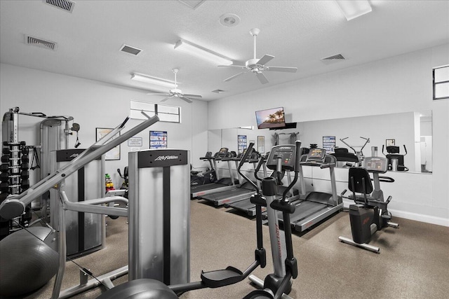 gym with visible vents, ceiling fan, and a textured ceiling