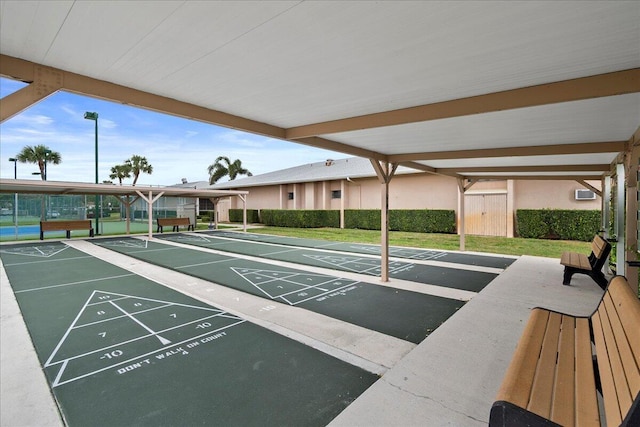 view of home's community with shuffleboard and a lawn