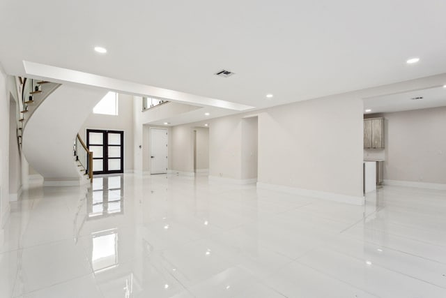 empty room featuring light tile patterned floors and french doors