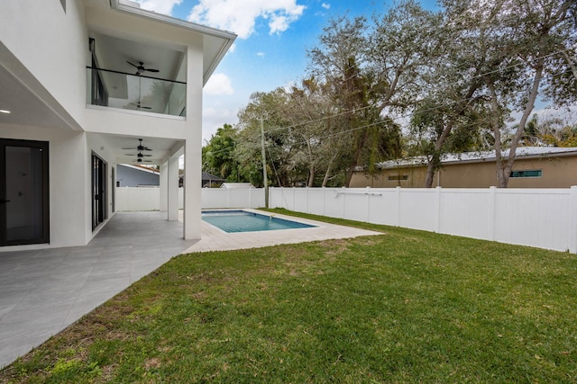 view of swimming pool with ceiling fan, a patio area, and a lawn