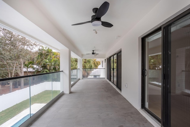 view of patio with ceiling fan and a balcony