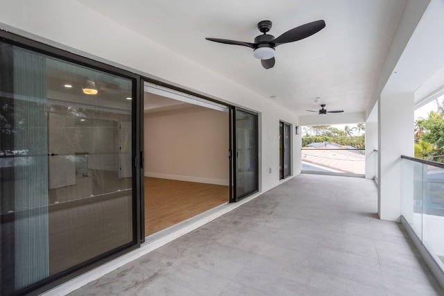 view of patio with ceiling fan and a balcony