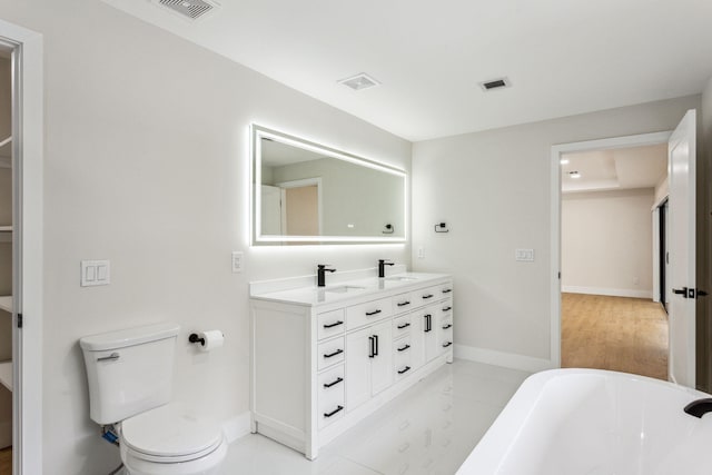 bathroom featuring toilet, a bathtub, and vanity