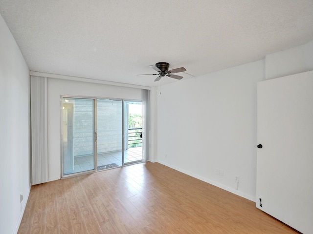 empty room featuring a textured ceiling, light wood-type flooring, and ceiling fan