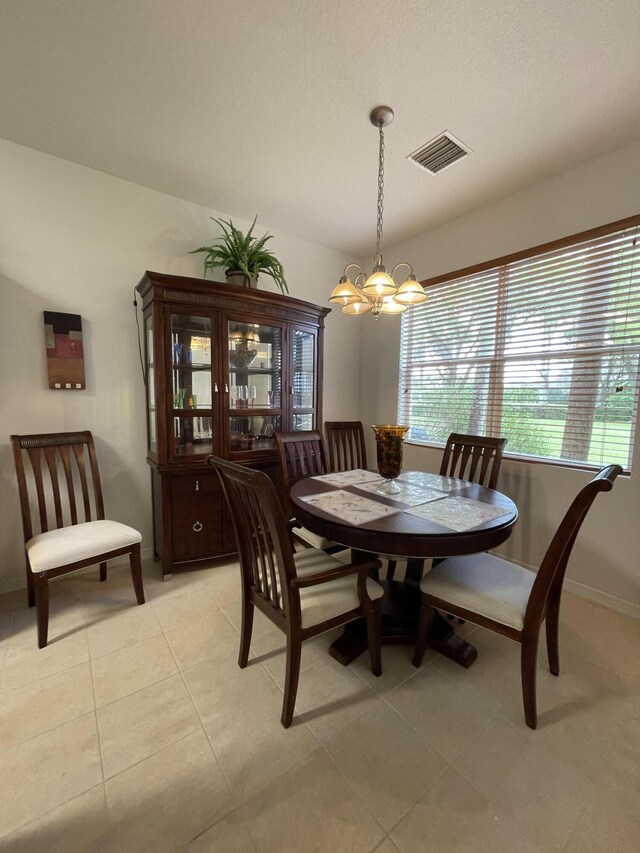 tiled dining space featuring an inviting chandelier