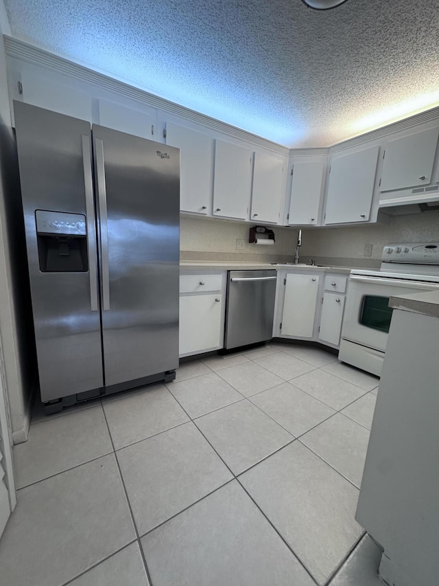 kitchen with a textured ceiling, white cabinetry, stainless steel appliances, sink, and light tile patterned floors