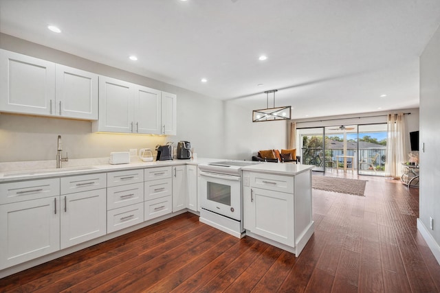 kitchen featuring kitchen peninsula, white cabinets, and white electric range oven