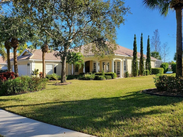 mediterranean / spanish home featuring a garage and a front lawn