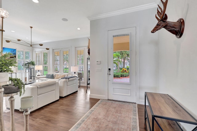 entrance foyer with a chandelier, crown molding, and hardwood / wood-style floors