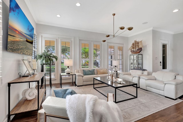 living room with a wealth of natural light, ornamental molding, wood-type flooring, and a chandelier