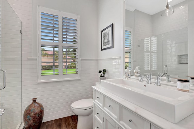 bathroom featuring toilet, vanity, a shower with shower door, and hardwood / wood-style floors