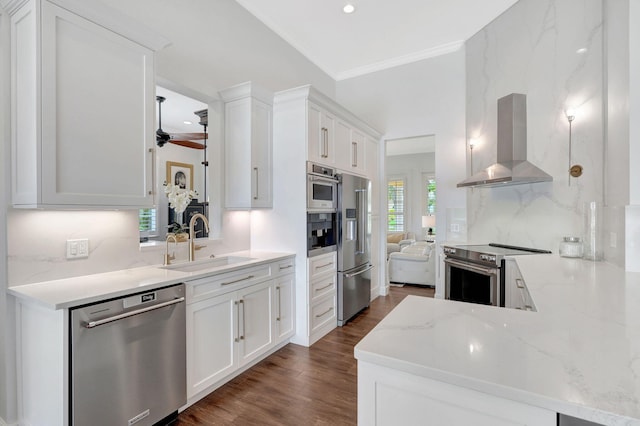 kitchen with sink, appliances with stainless steel finishes, extractor fan, and white cabinetry