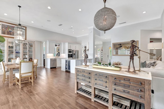 interior space with decorative light fixtures, white cabinets, a notable chandelier, and appliances with stainless steel finishes