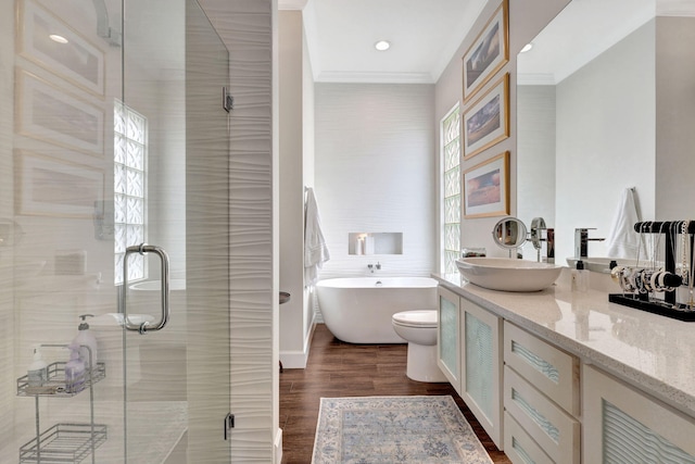 bathroom with wood-type flooring, vanity, ornamental molding, and shower with separate bathtub