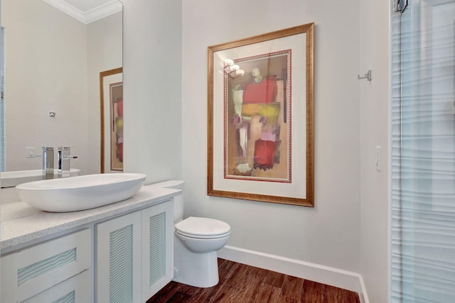 bathroom with crown molding, vanity, wood-type flooring, a shower, and toilet