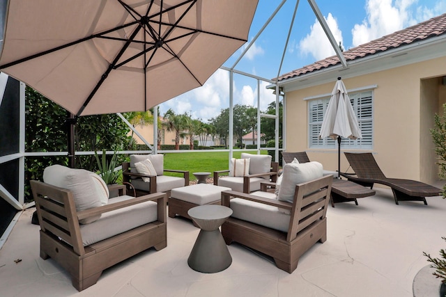 view of patio with outdoor lounge area and glass enclosure