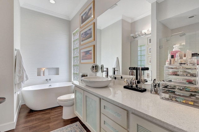 full bathroom with hardwood / wood-style floors, separate shower and tub, vanity, ornamental molding, and toilet