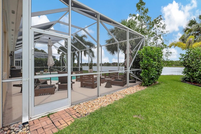 view of yard featuring a water view, a patio area, and glass enclosure