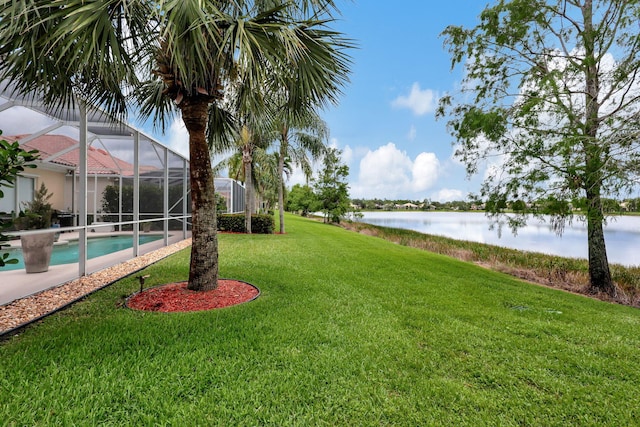 view of yard featuring glass enclosure and a water view