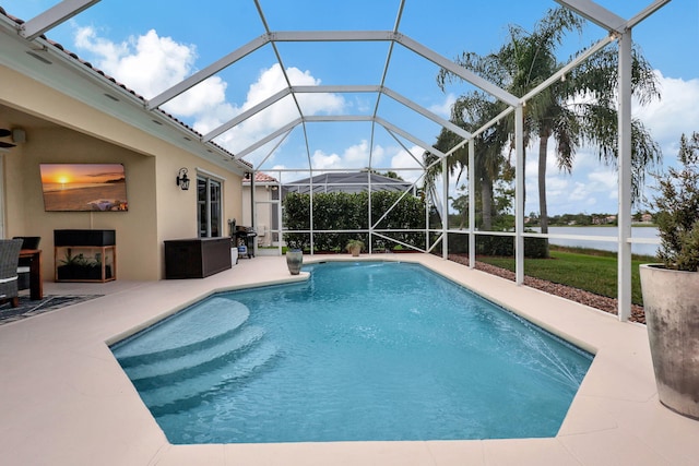 view of pool with a patio, a water view, and glass enclosure