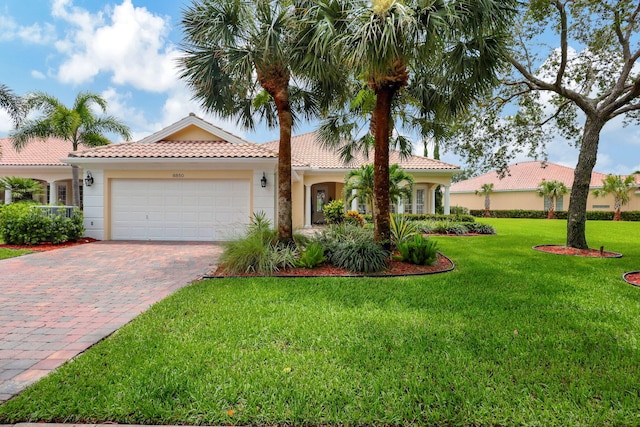 mediterranean / spanish home with a garage and a front lawn