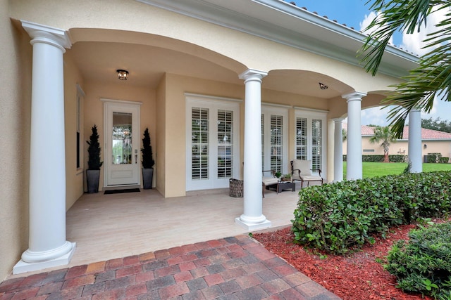 view of exterior entry featuring covered porch